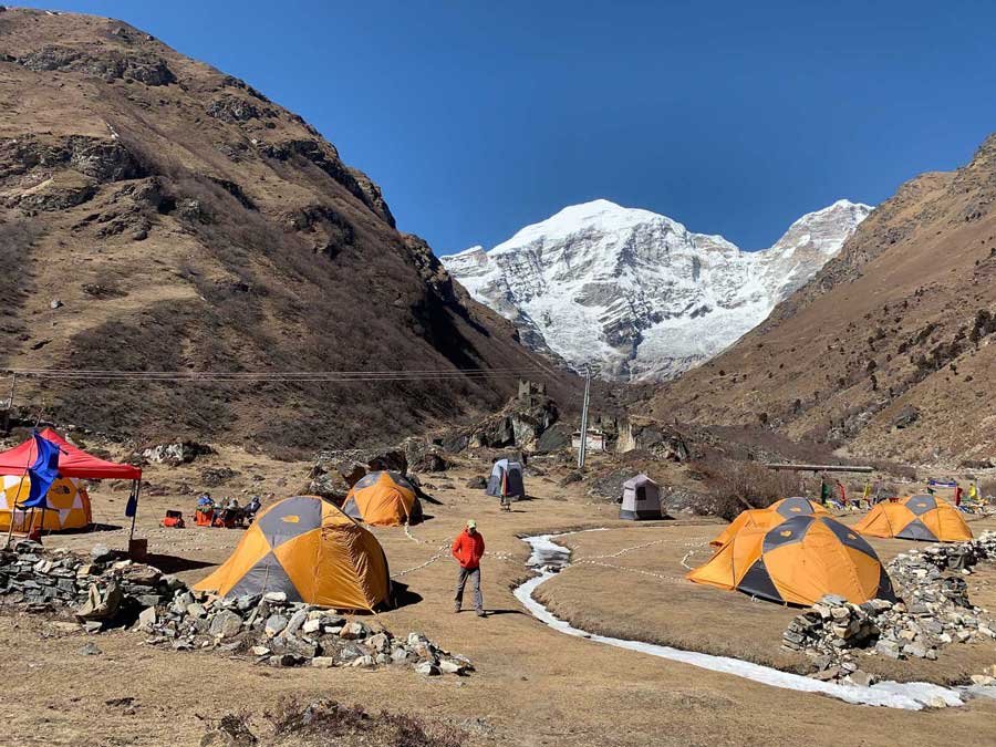 Trekking camp beneath a snow-capped Himalayan peak in Bhutan