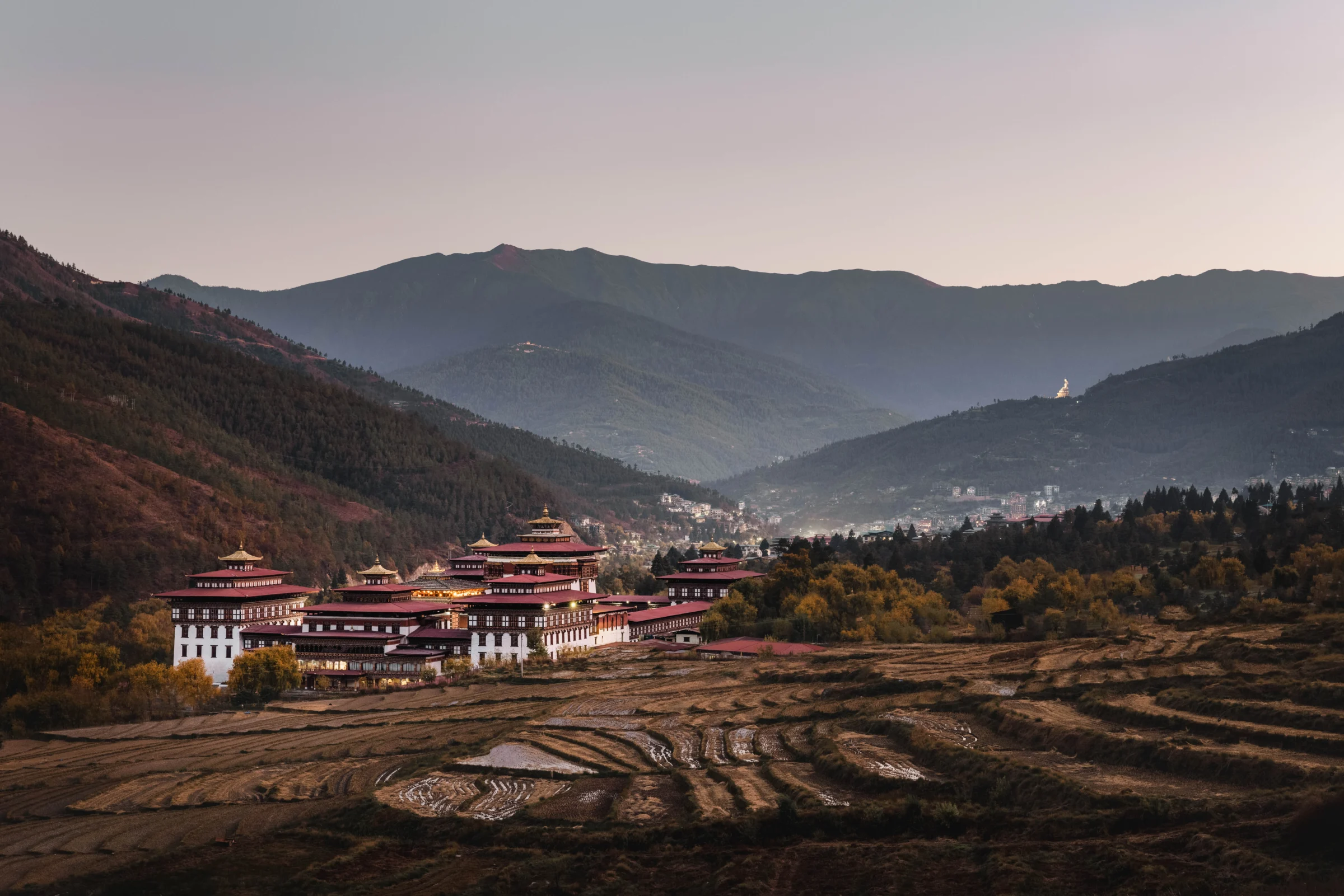 Farmland and houses in a Bhutanese valley at dusk
