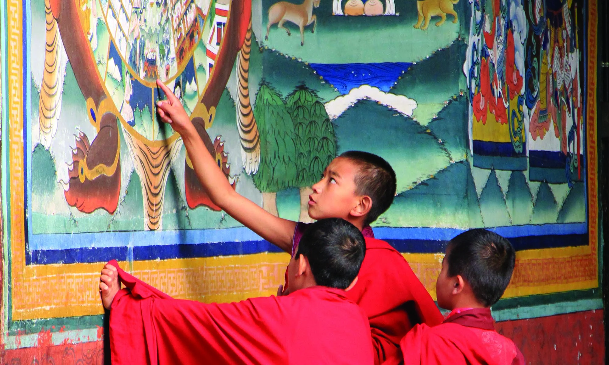 An artist painting a traditional Bhutanese mural in Lhuentse