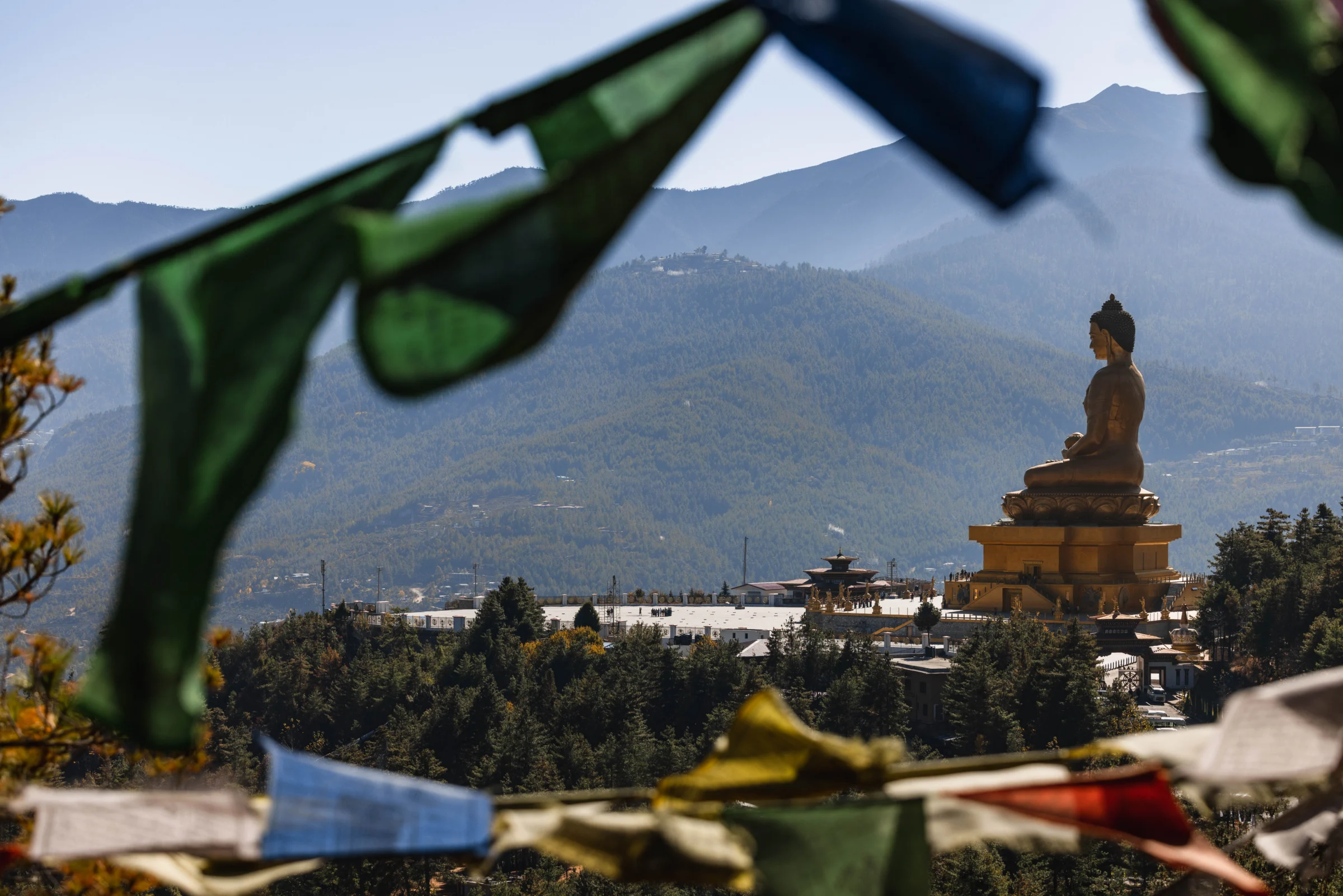Prayer flags with Buddha Dordenma in the distance above Thimphu